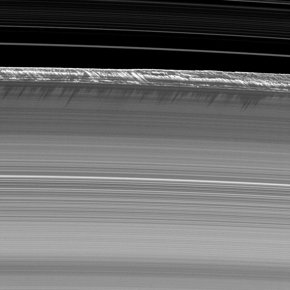 Vertical structures, among the tallest seen in Saturn's main rings, rise abruptly from the edge of Saturn's B ring to cast long shadows on the ring in this image taken by NASA's Cassini spacecraft two weeks before the planet's August 2009 equinox.