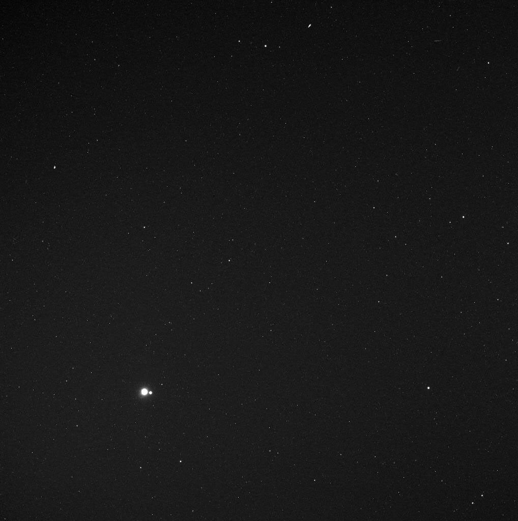 In the lower left portion of this image, the Earth can be seen, as well as the much smaller Moon to Earth's right.