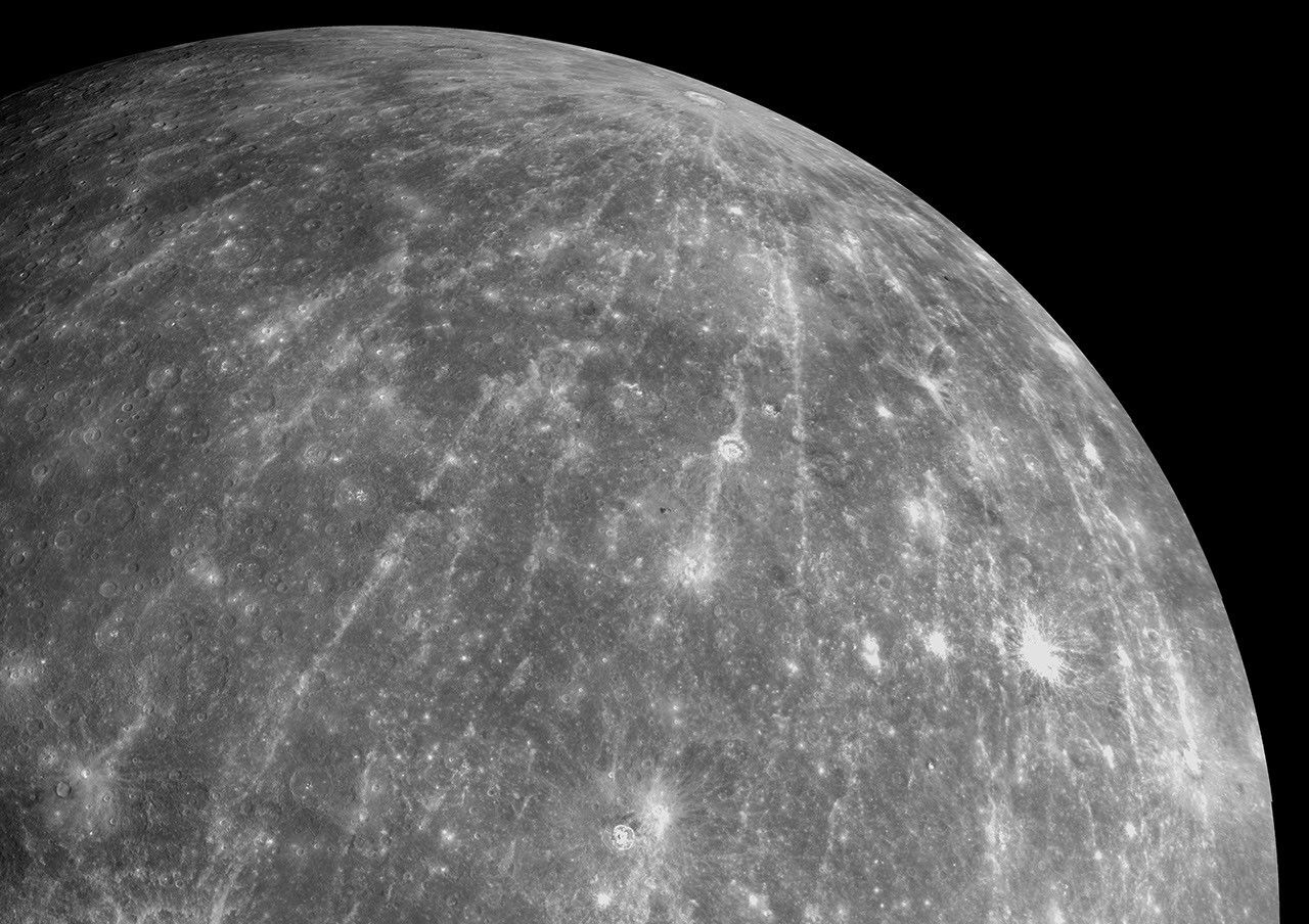 Cratera Hokusai em Mercúrio com extensos raios brilhantes se espalhando pela superfície do planeta, capturada pela missão MESSENGER da NASA