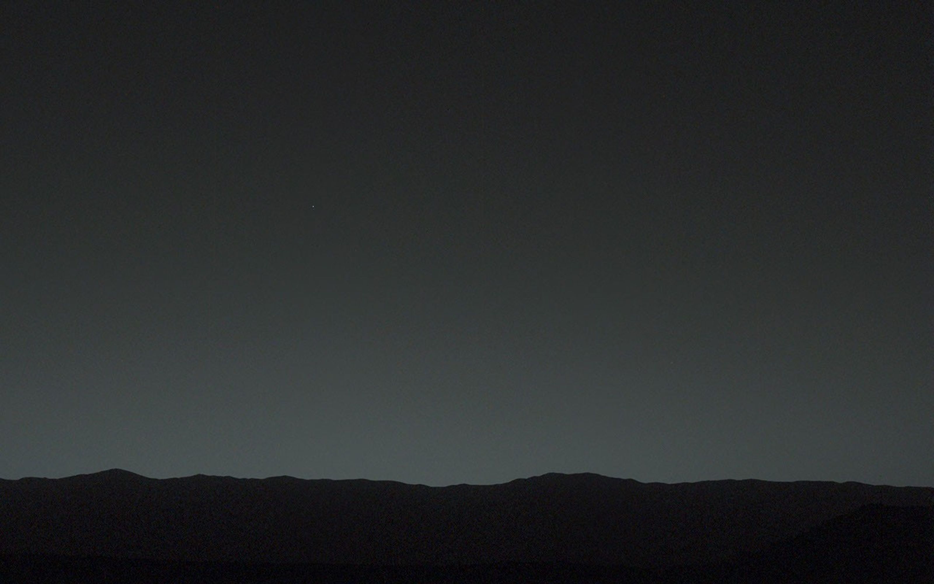 This view of the twilight sky and Martian horizon taken by NASA's Curiosity Mars rover includes Earth as the brightest point of light in the night sky.