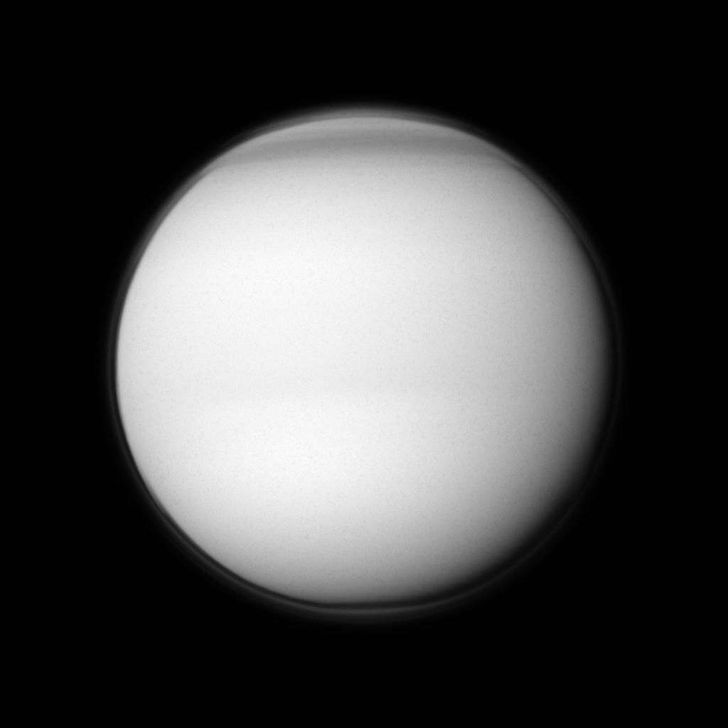 The Cassini spacecraft examines Titan's north polar hood, the part of the atmosphere of Saturn's largest moon appearing dark at the top of this image.