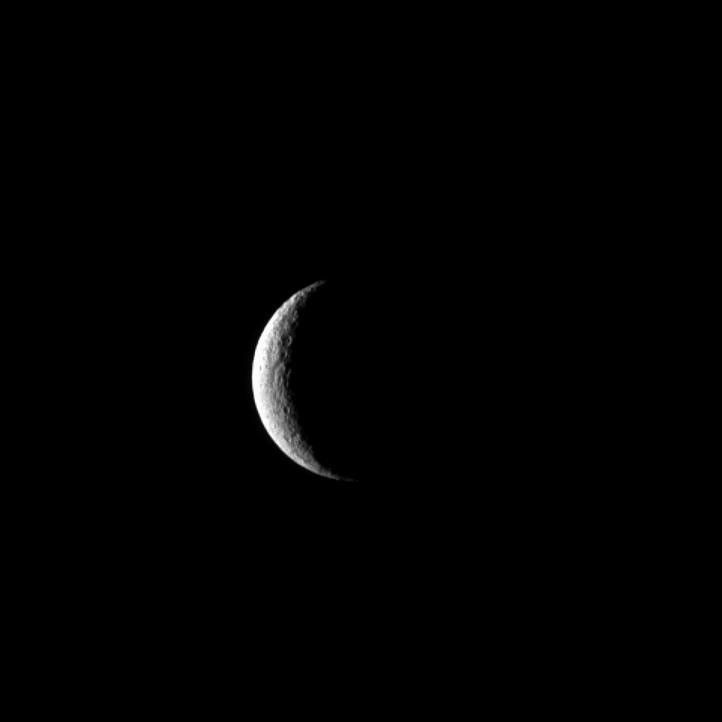 The Cassini spacecraft captures Saturn's moon Rhea at crescent phase, a view never visible from Earth.