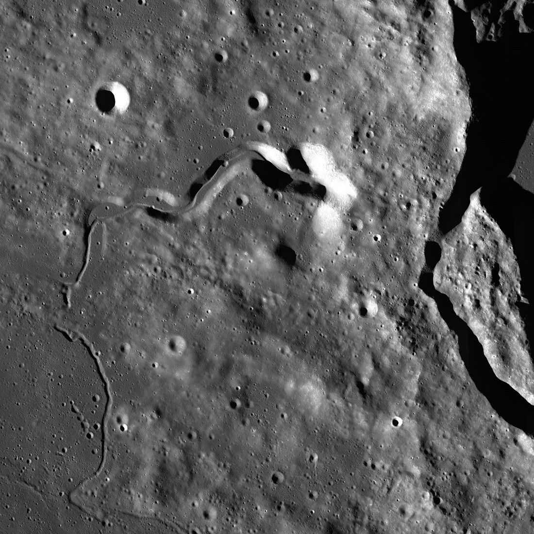 black and white view from above of valley carved anciently by lava