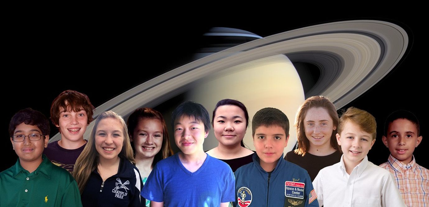 Smiling kids in front of picture of Saturn