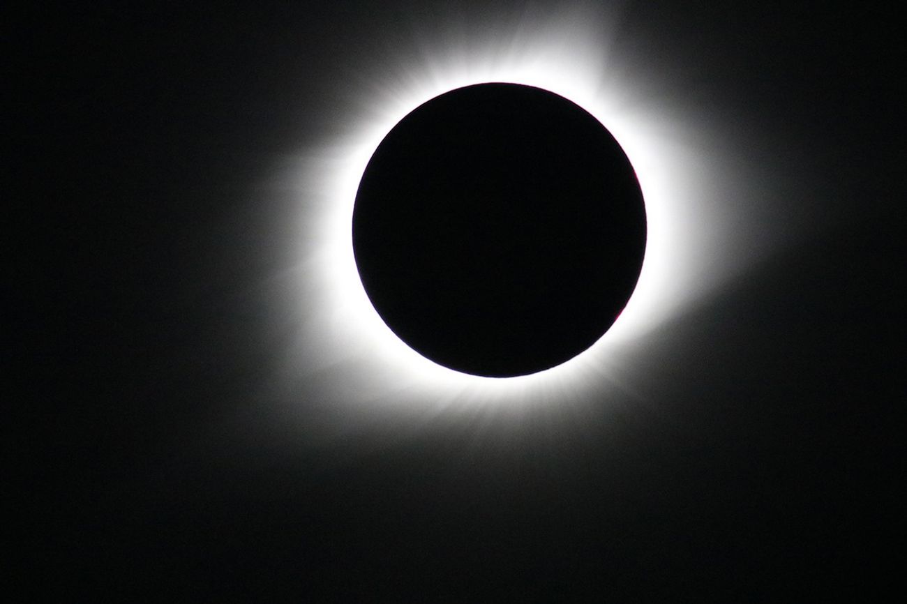 eclipsed sun surrounded by visible glowing corona