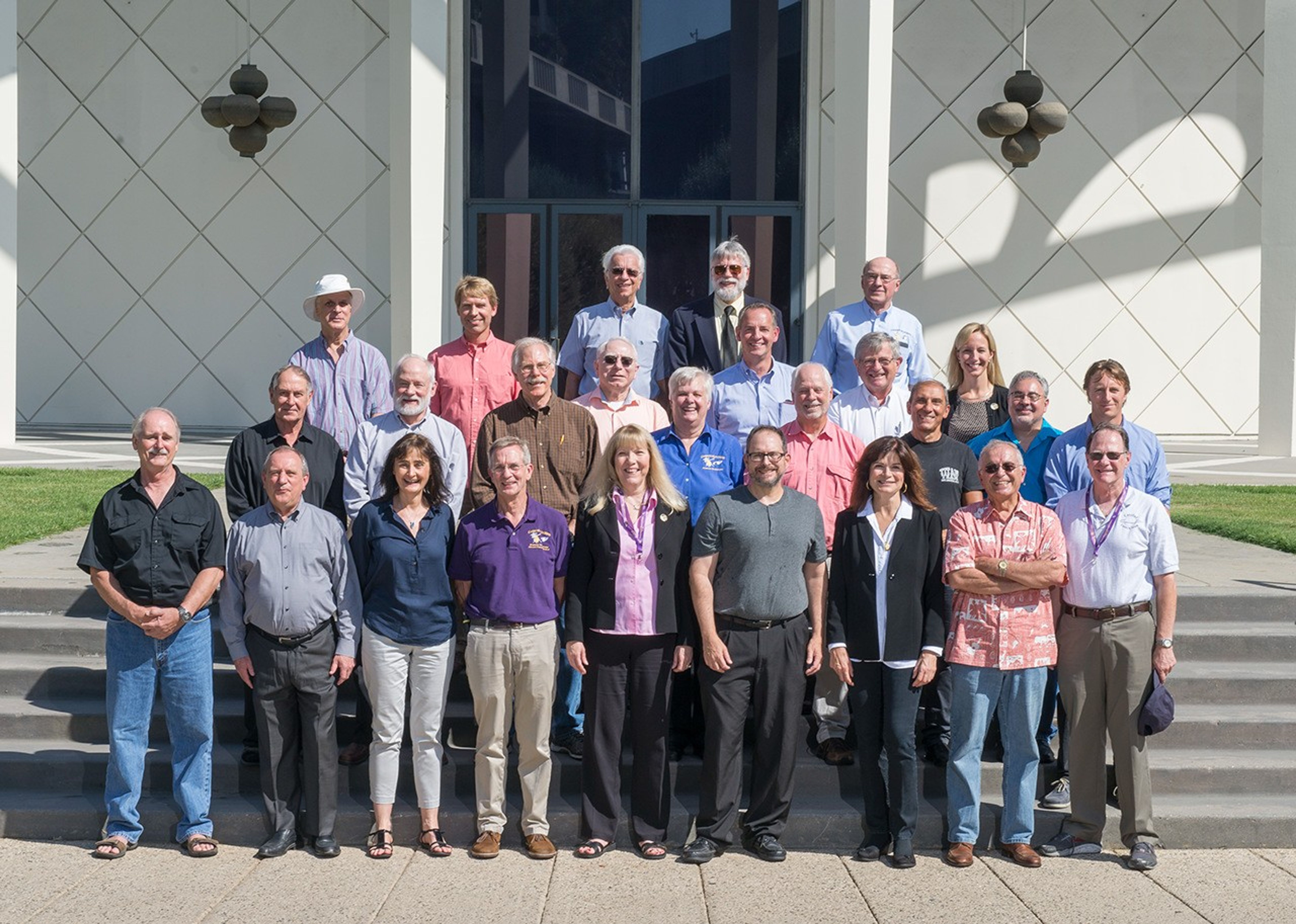 Color image of small group of men and women standing on stairs.