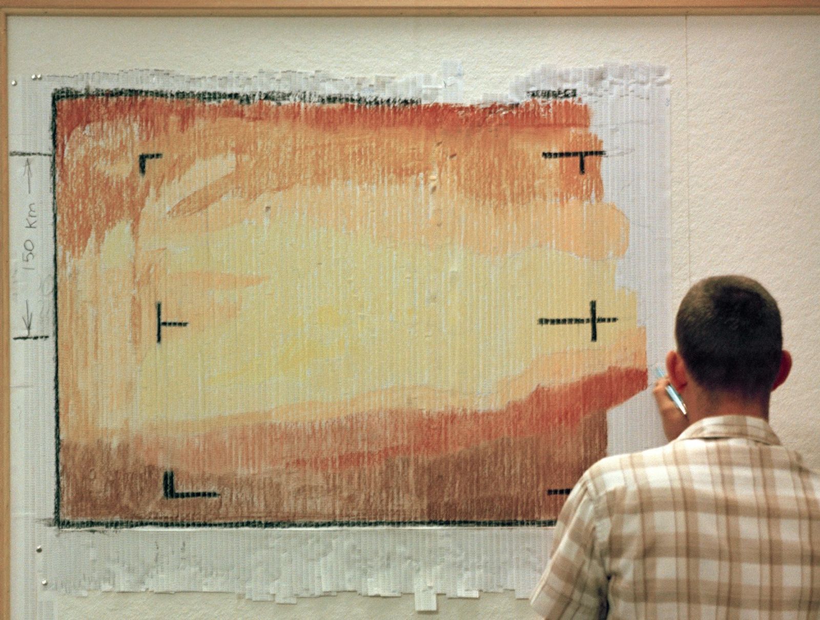 Man coloring on spacecraft data with pastel sticks.