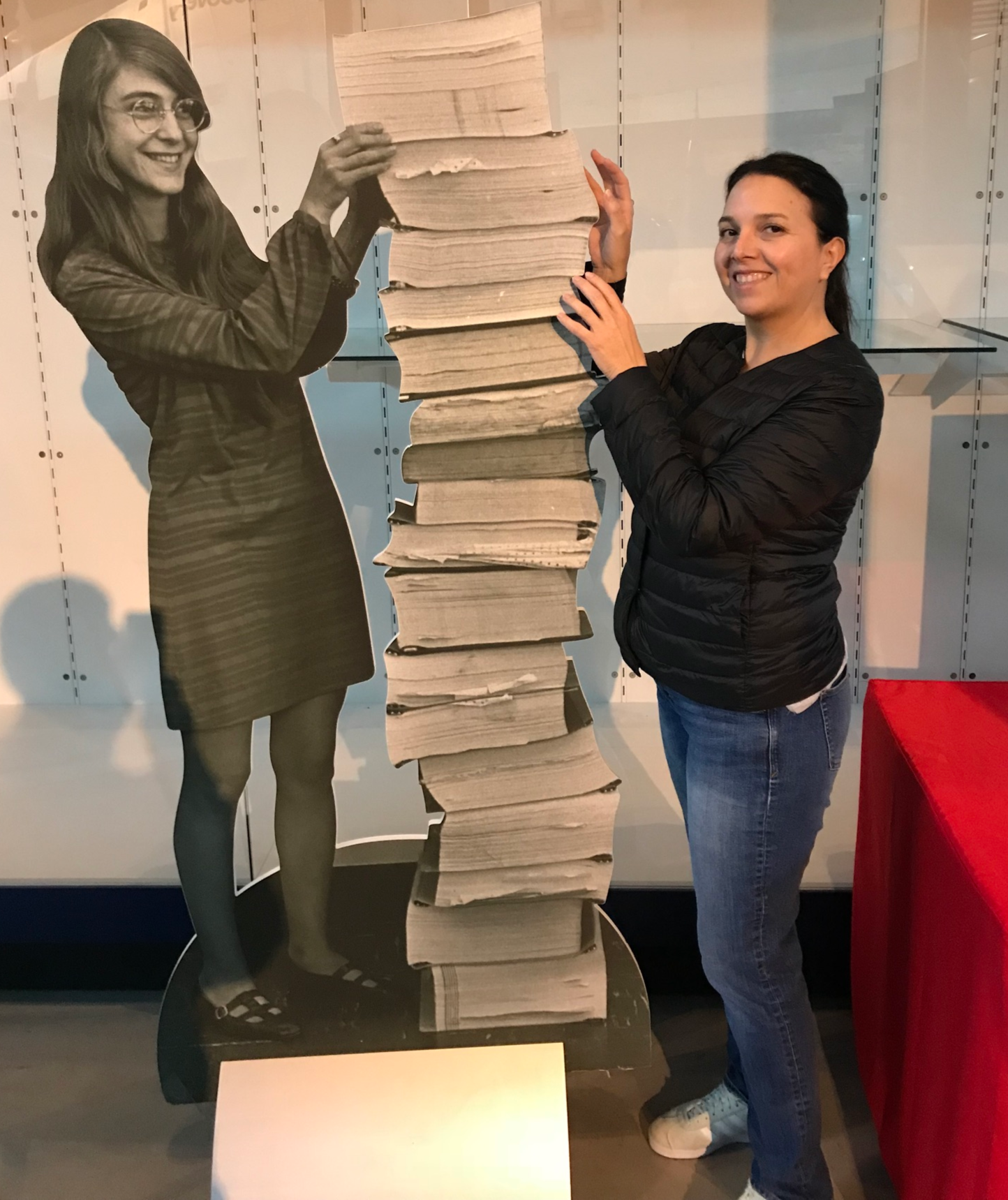 Elisa Quintana poses with a cutout of Margaret Hamilton and the code Hamilton wrote to send NASA astronauts to the Moon.