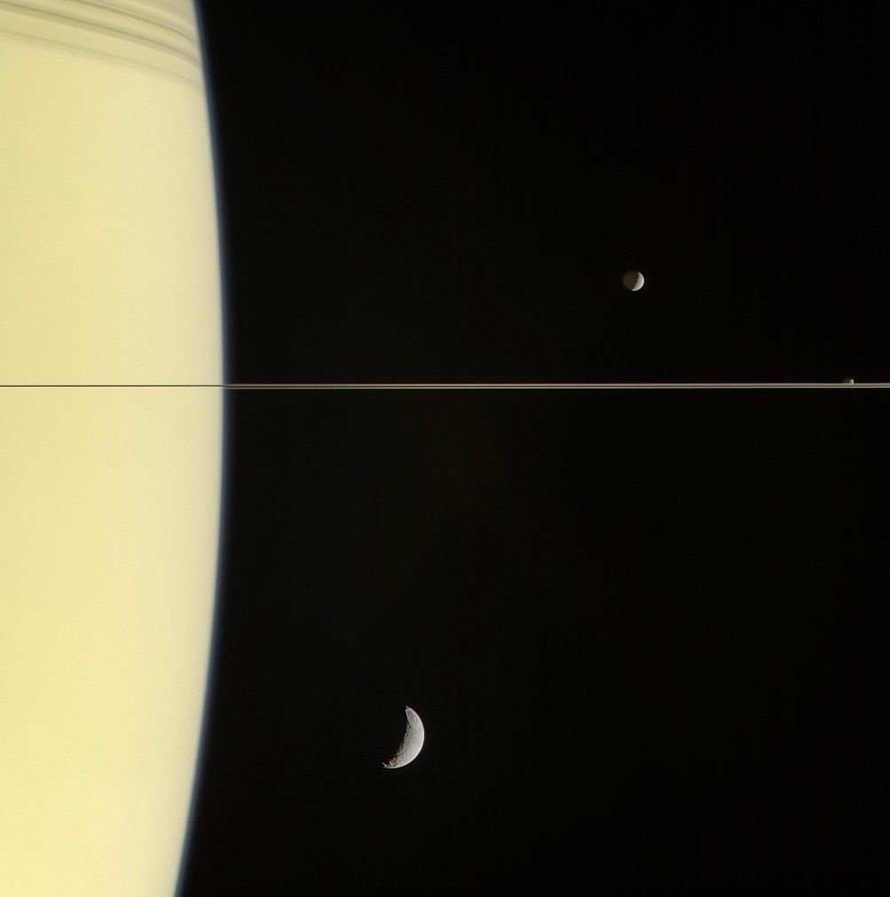 curve of saturn with several moons visible nearby