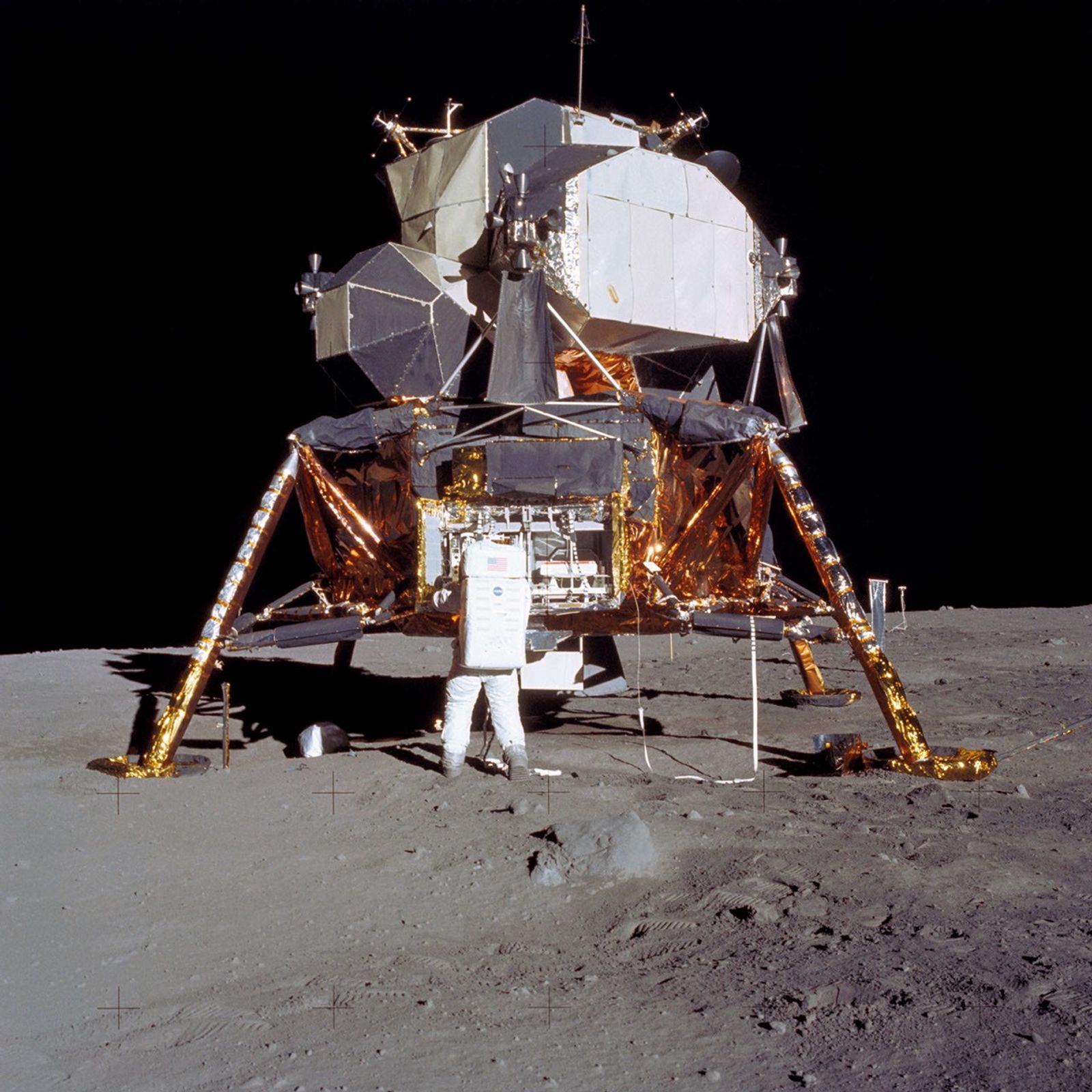 Astronaut standing outside the Apollo 11 Lunar Module on the Moon.