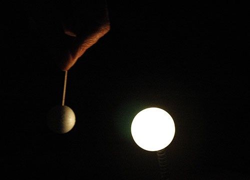 White circle next to a half lit yellowish orb.