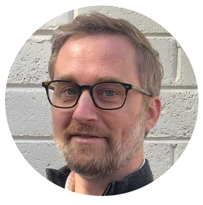 Photo of Christopher Andert He has a light beard, glasses and a friendly smile.