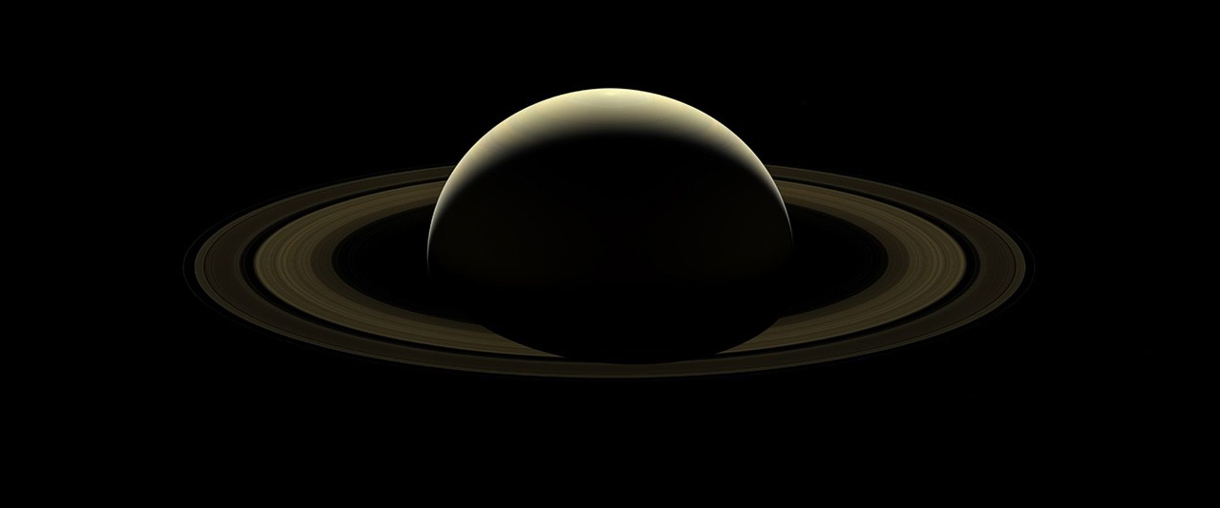 planet and rings backlit by sun