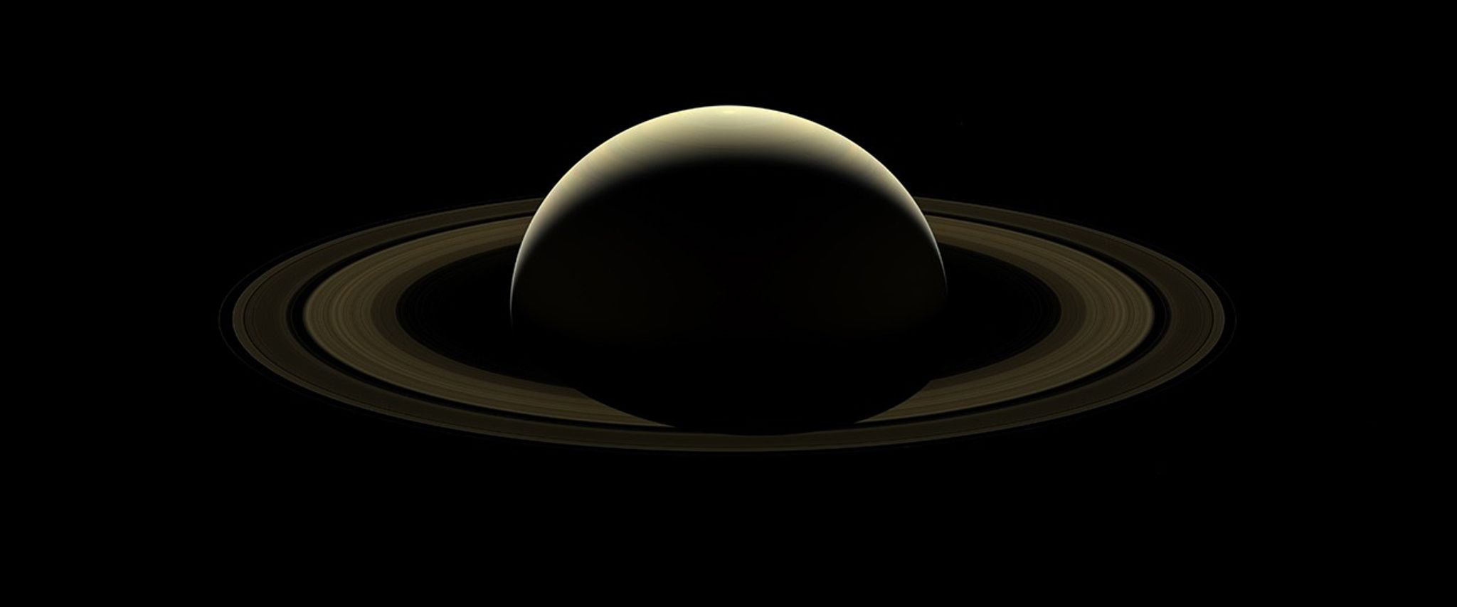 planet and rings backlit by sun