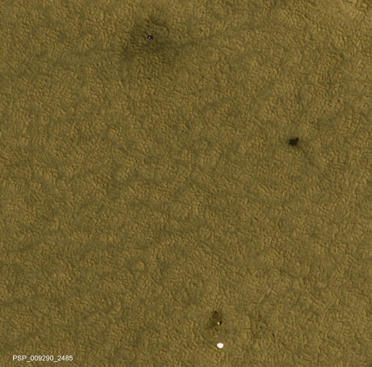 Three patches of darker ground -- where landing events removed dust